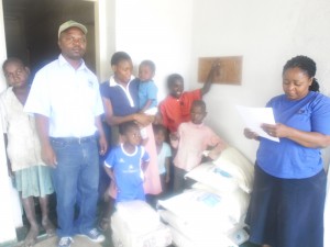 in white tshirt NSSA registry supervisor Livison Muthonga, holding baby Elizabeth Goko and wearing blue T shirt NSNSNSSApub